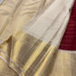 Detailed shot of ivory body of the saree with rich gold zari temple border in pure silk