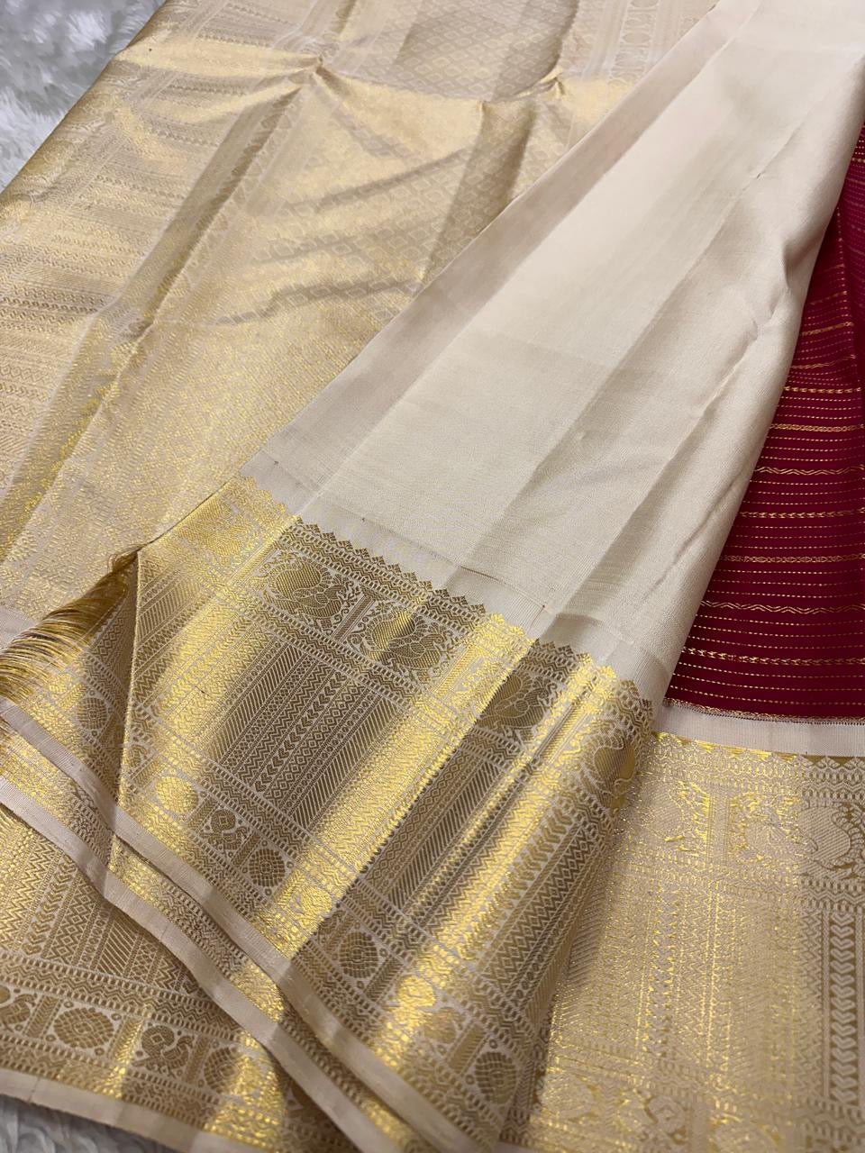 Detailed shot of ivory body of the saree with rich gold zari temple border in pure silk