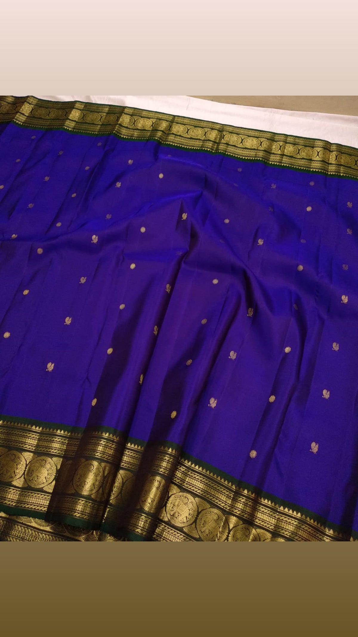 Royal-violet pure silk Kanchipuram saree with bottle-green Sorgavaasal Mayil border and antique-gold zari.