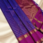 An heirloom-worthy drape woven in the finest 2G pure silk, this traditional Kanchipuram saree brings together the timeless beauty of zari buttas and checks in a rich purple body. The contrast magenta-pink rettapet border stands bold and elegant