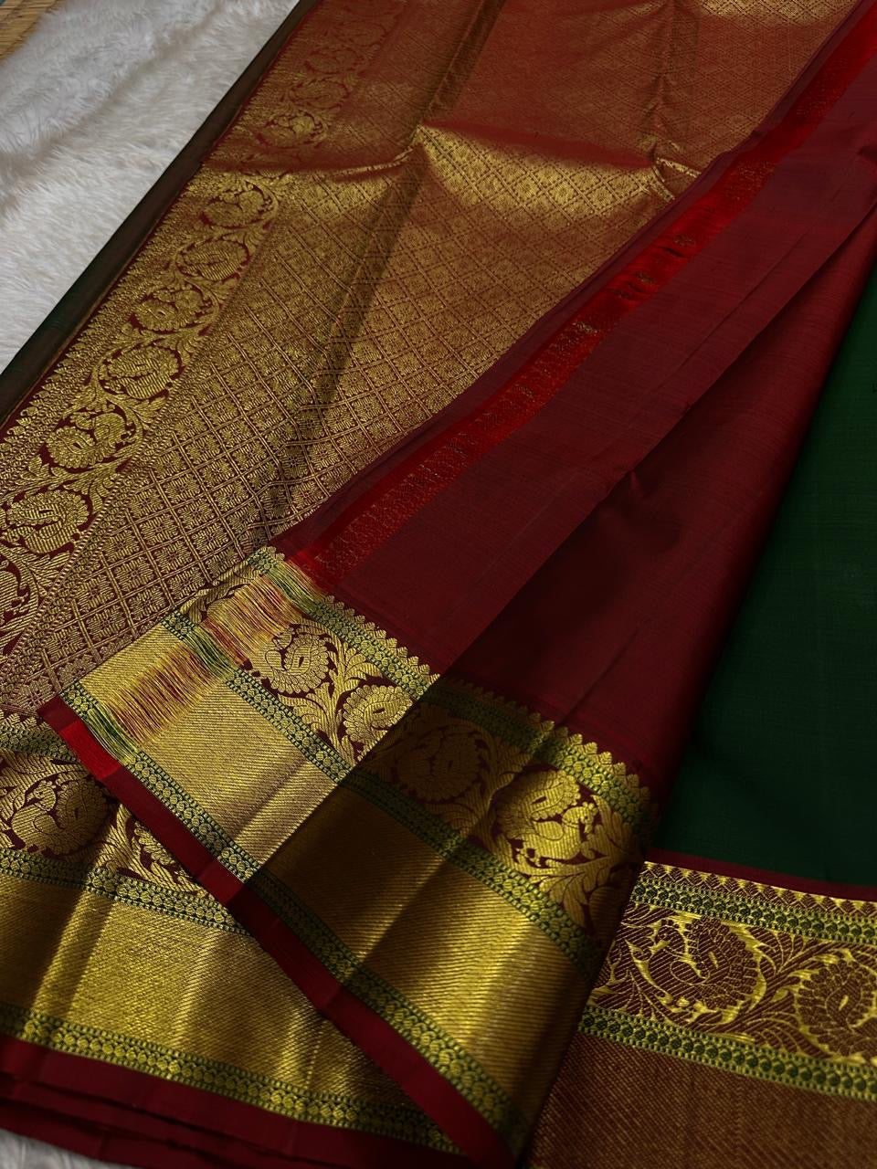 Emerald Glow ✨ – Pure Kanchipuram Silk Saree

Deep Green Body with Gold Floral Buttas

Maroon Korvai Border with Peacock & Floral Zari Motifs

Grand Gold Zari Brocade Pallu with Diamond Lattice Weave

Silk Mark Certified | Fall & Pico Done | Blouse Stitch