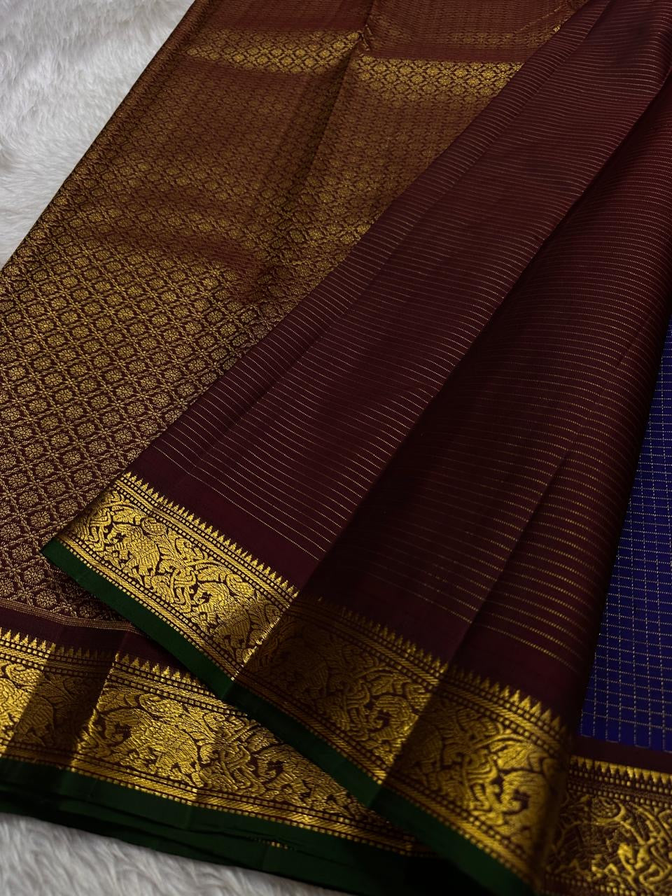 Midnight Oosikattam ✨ – Pure Kanchipuram Silk Saree
Deep Midnight Blue Body in Oosi Zari Kattam with Leaf Buttas
Maroon Korvai Border with Green Selvedge & Elephant Motifs
Opulent Maroon Pallu with Intricate Gold Zari Brocade
Silk Mark Certified |
