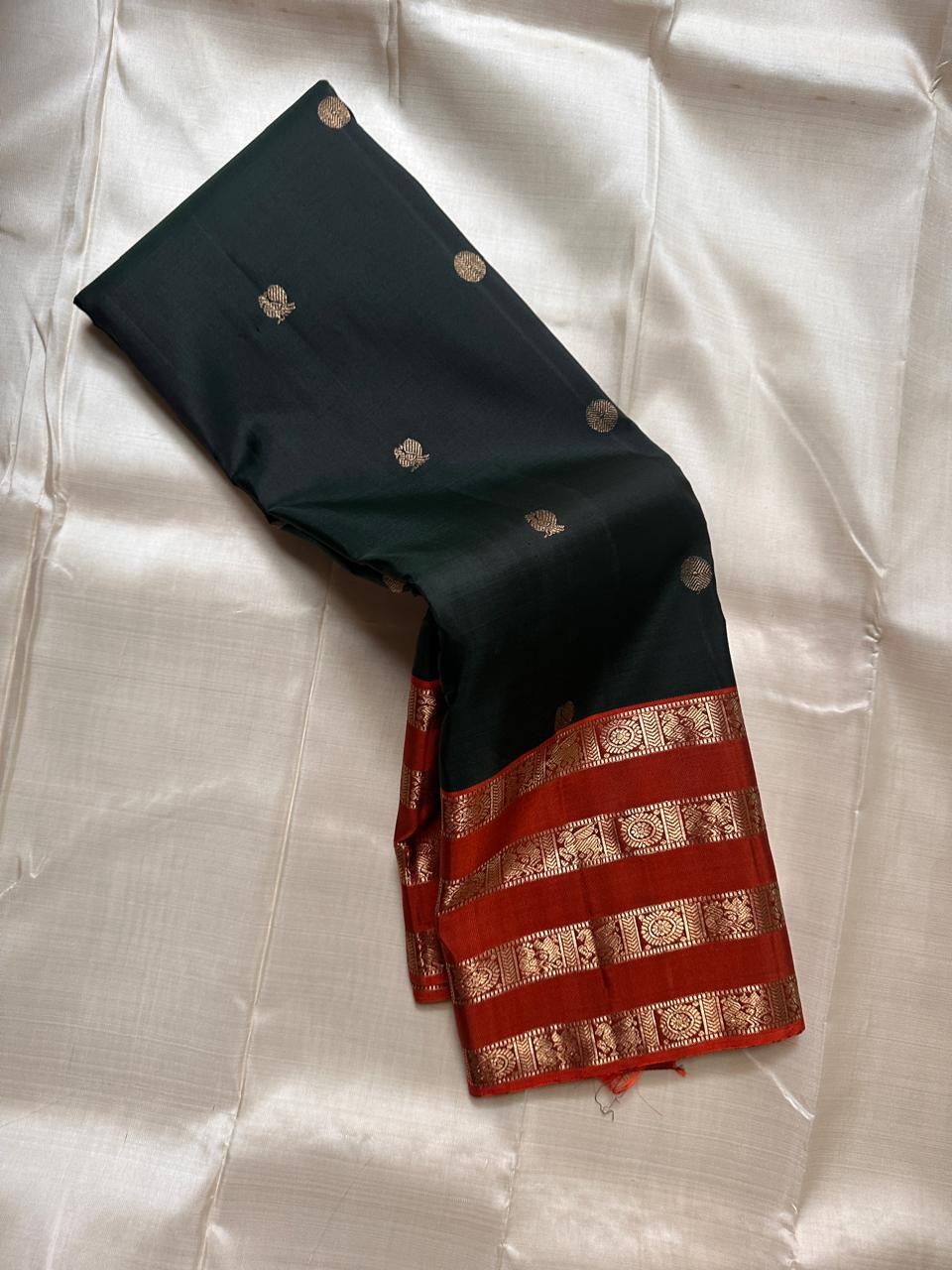 Pachai Mayil Chakram Varisaipet — Pure Kanchipuram Silk Saree
Deep pachai (bottle green) body with antique-gold chakram buttas, rust-vermillion varisaipet borders, and a radiant kesari-orange zari pallu.
Silk Mark Certified • Blouse Stitching Available