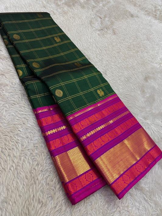 Emerald Blossom ✨ – Pure Kanchipuram Silk Saree
Bottle-Emerald Green Body with Zari Checks & Buttas
Korvai Rani-Pink & Purple Contrast Border with Rich Zari
Grand Rani-Pink Brocade Pallu with Temple motifs , Silk Mark Certified, delivery in 2 weeks