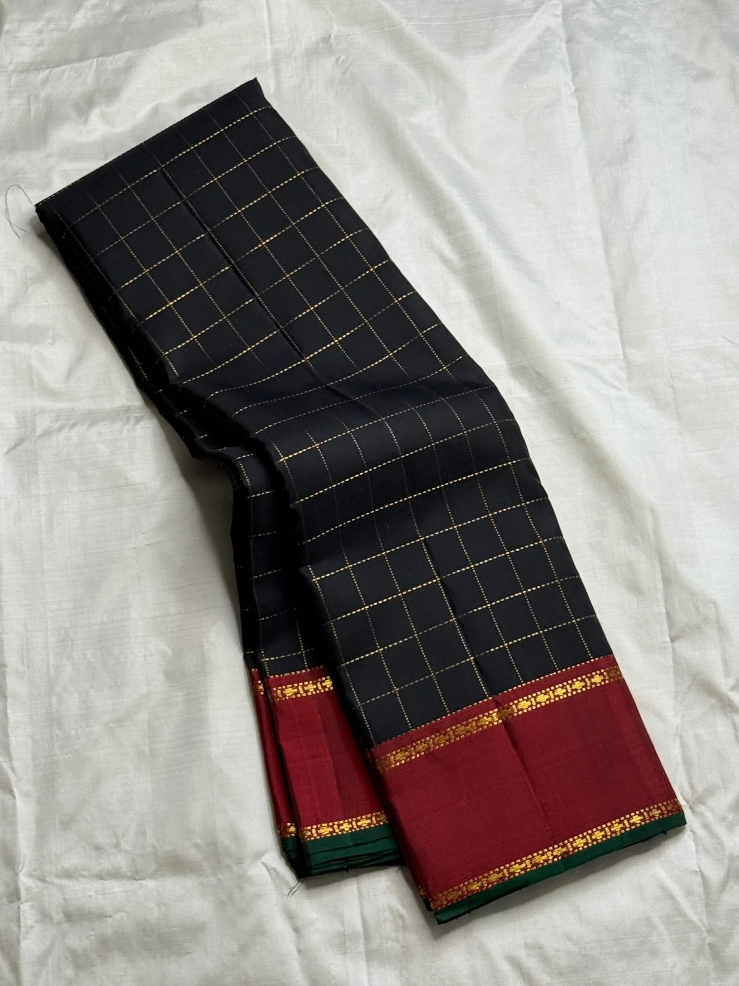 Black and red Kanchipuram Zari Kattam saree folded flat — full length view