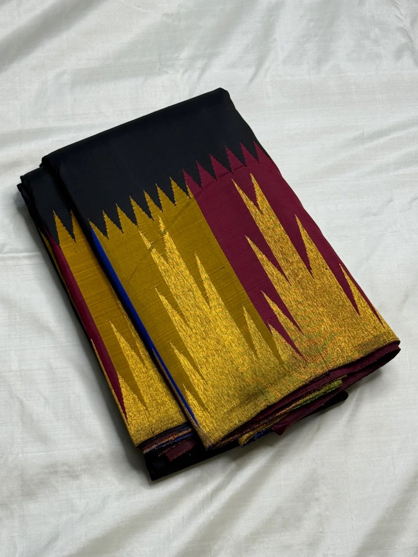 Deep black Kanchipuram saree body with sparse magenta silk thread butta — close-up