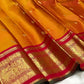 Close-up of burnt orange mulberry silk body with gold zari Mayil butta and Kamalam butta