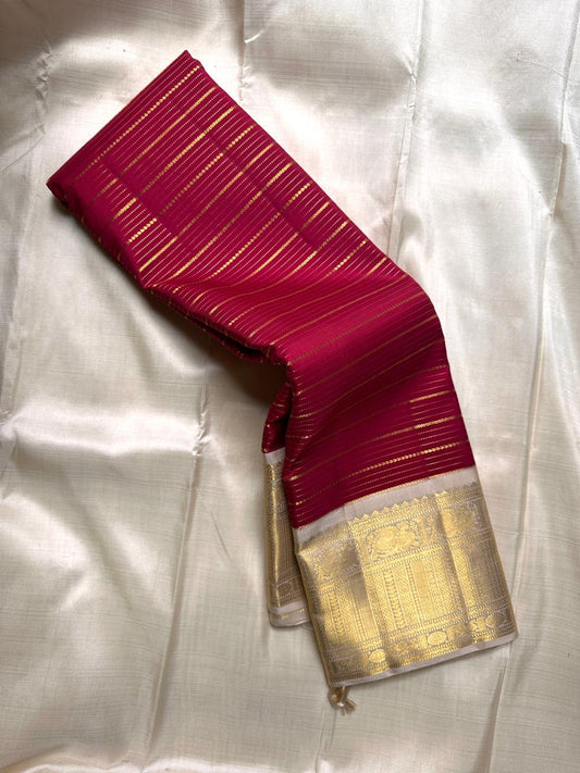 Close-up of red striped pallu and ivory body of Kanchipuram silk saree with gold temple border