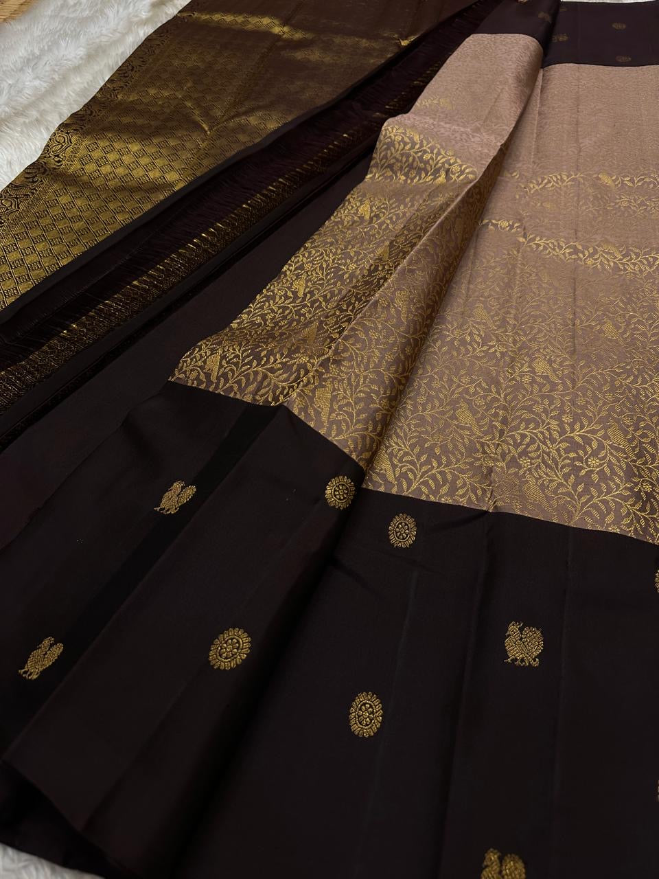 Mauve Mayil – Pure Kanchipuram Silk Saree with Plum Body & Dusty-Rose Pallu
Deep plum silk adorned with delicate golden buttas.
Broad antique zari borders with kattam.
Dusty-mauve pallu in intricate vine jaal. Silk Mark Certified, delivery in 2 weeks