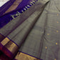 Varnam – Dove Tail Gray & Purple, a Kanchipuram silk saree where elegance meets bold expression. The soft dove tail gray base is adorned with vibrant magenta checks,Framed by a rich purple zari border and finished with an intricate contrast pallu