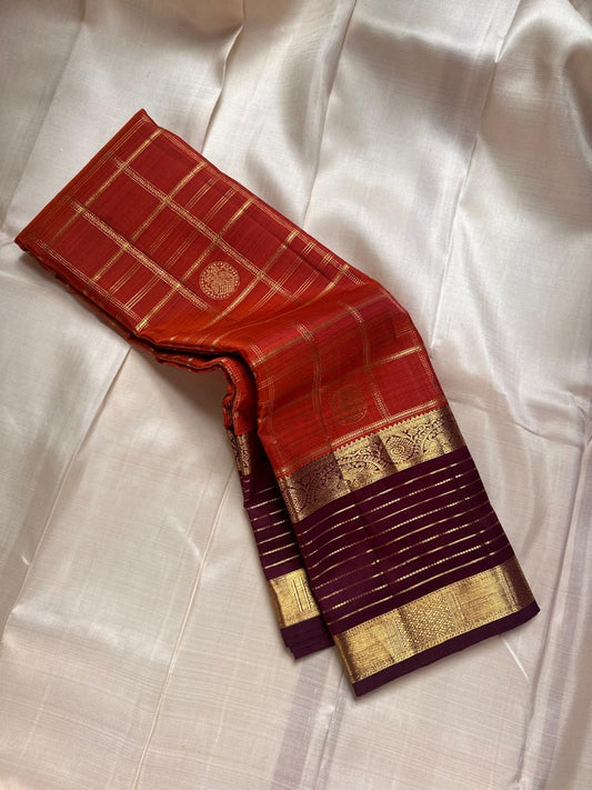 Cinnamon Kattam – Pure Kanchipuram Silk Saree
Vermillion red body with gold kattam checks & floral  buttas
Contrast plum purple korvai borders with rich zari weave
Grand zari pallu with lattice & floral motifs in gold
Silk Mark Certified ships in 2weeks