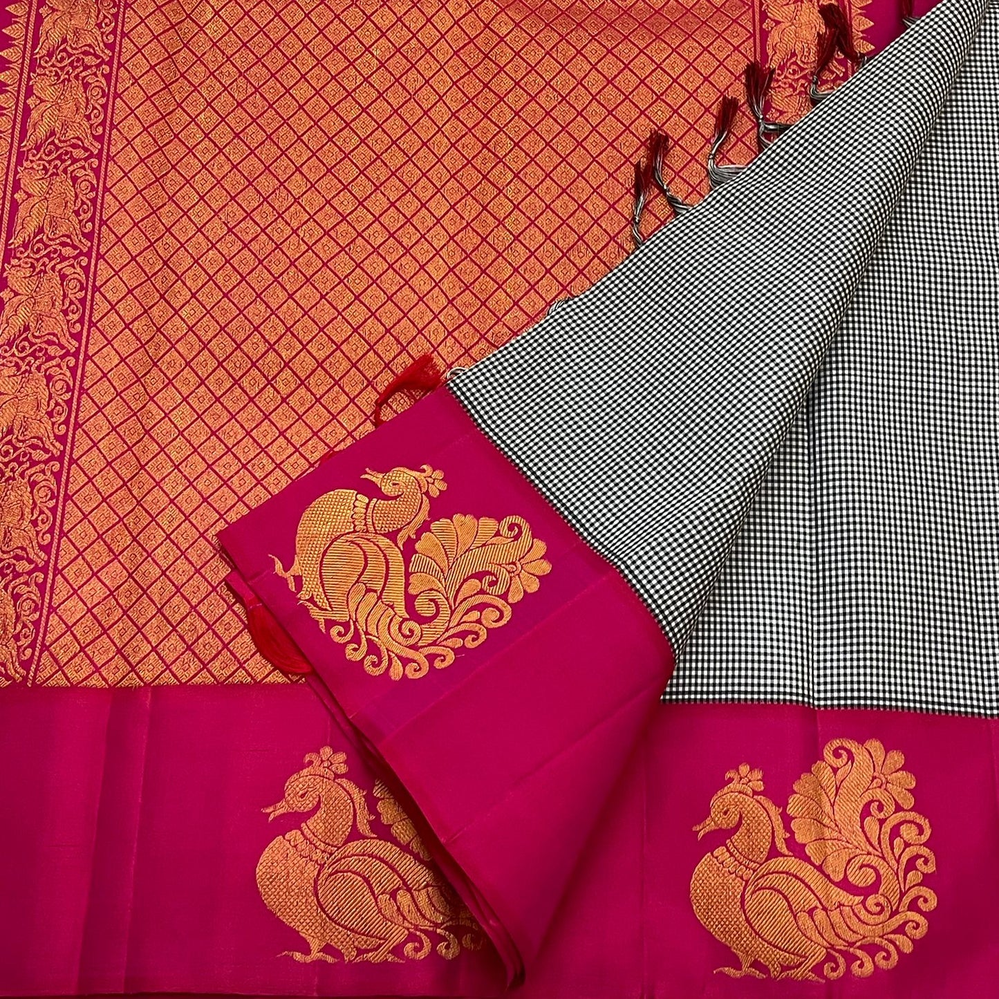 Aaradhana Kattam — Pure Kanchipuram Silk Saree (Black & White × Rani Pink)
Classic black-and-white micro checks with rich rani-pink korvai borders and zari peacock motifs
Silk Mark Certified • Fall & Pico Done • Blouse Stitching Available ($30) • Free Shi