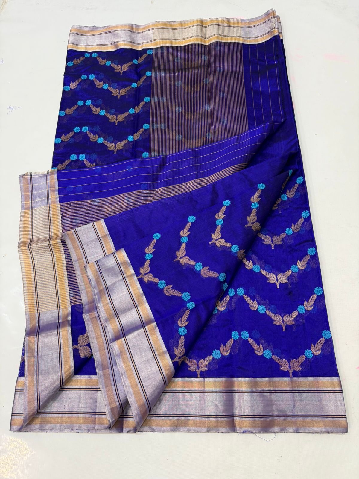 Pure Silk Chanderi Saree in Royal Blue with Teal–Gold Floral Vine Motifs
Silver–Gold Tissue Borders with Subtle Striped Pallu
Fall & Pico Done • Blouse Stitching Available ($30) • Free Shipping within USA • Ships in Two Weeks