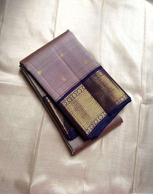Dovetail Grey – Pure Kanchipuram Silk Saree
Dove-grey body with petite kamalam & manga zari buttas ✨
Regal violet borders in chevron zari weave 🌸
Opulent violet pallu with diamond lattice design 💜

Silk Mark Certified, delivery in 2 weeks