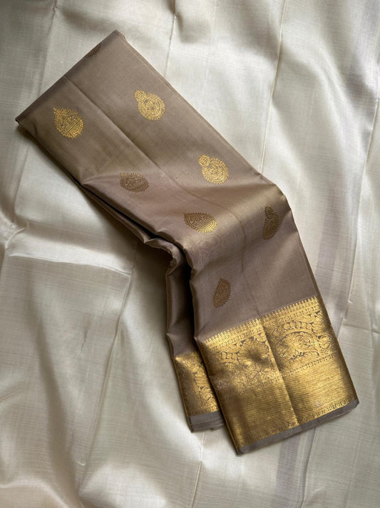 Chiku Orchard – Pure Kanchipuram Silk Saree
Elegant Chiku (Taupe) Body with Gold Paisley Buttas
Rich Antique Gold Zari Borders with Floral Motifs
Grand Gold Zari Pallu with Traditional Kattam Design
Silk Mark Certified | Ready to Ship | ships in two weeks