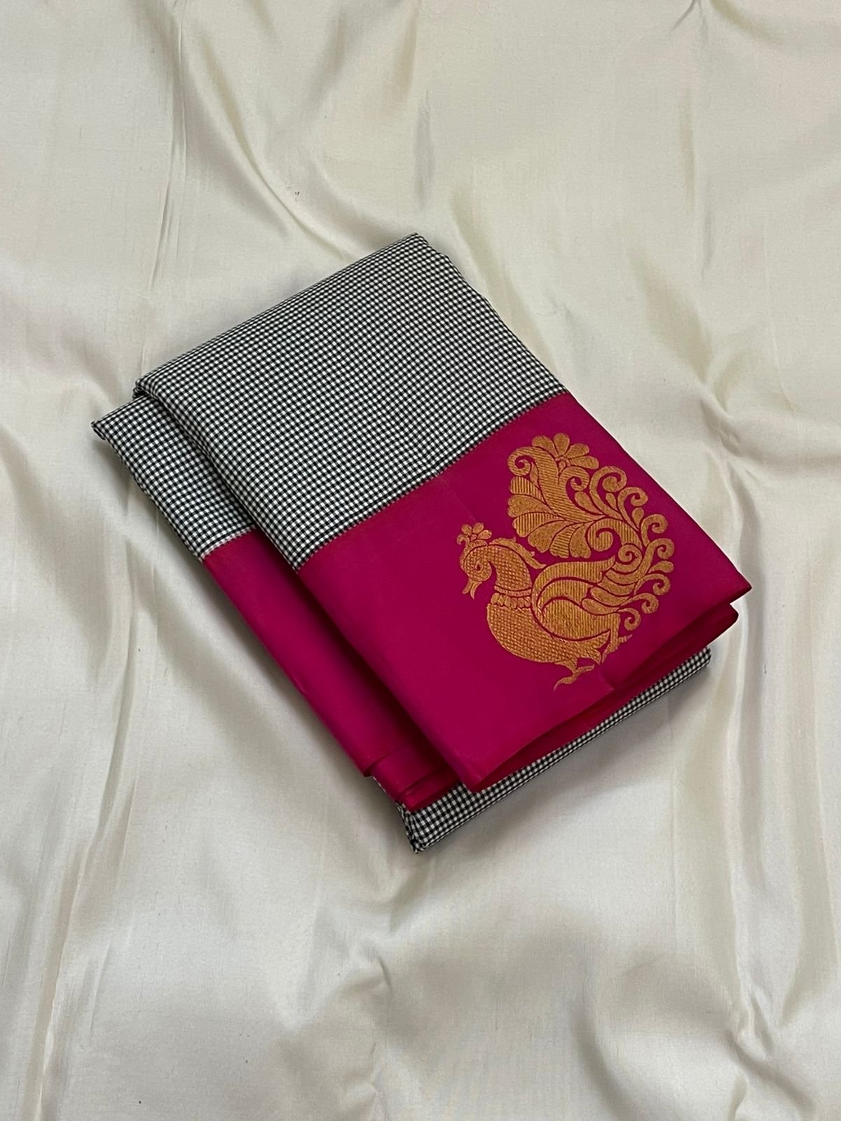 Aaradhana Kattam — Pure Kanchipuram Silk Saree (Black & White × Rani Pink)
Classic black-and-white micro checks with rich rani-pink korvai borders and zari peacock motifs
Silk Mark Certified • Fall & Pico Done • Blouse Stitching Available ($30) • Free Shi