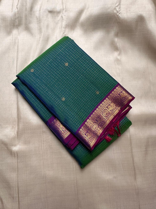 Nemaya – Green-Blue Shot Pure Silk Kanchipuram Saree with Peacock Zari Kattam & peacock with kamalam on  Border in purple . Ornate grid zari Pallu on purple comes with fully stitched padded blouse