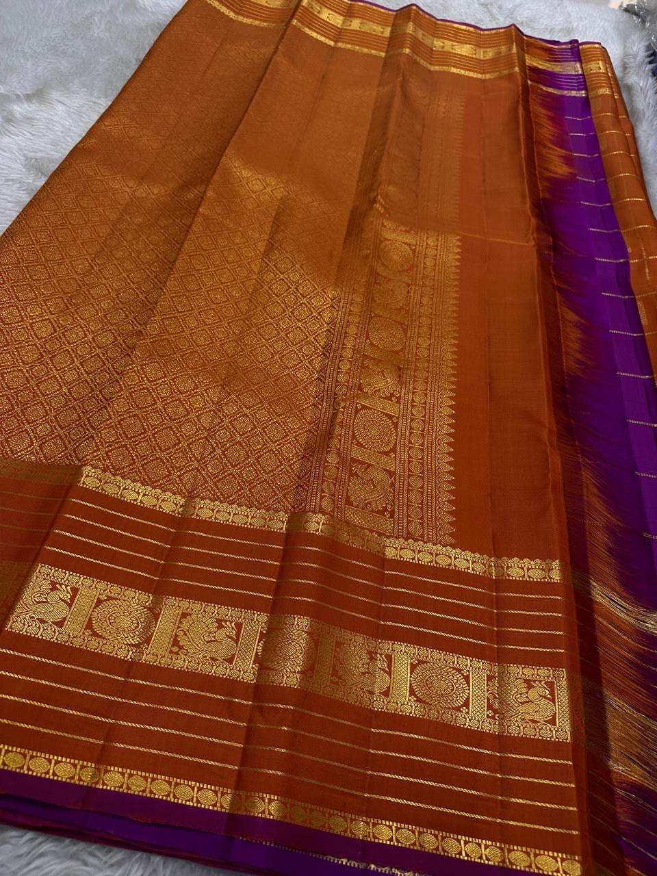 Pankajam 🌺 – Burnt Orange Kanchipuram Silk Saree with Zari Kattam, Dashed Lines, Kolam Motifs, Varisaipet Border with Thandavalam Zari Stripes, Rudrakshpet, Annam & Kamalam Motifs, Deep Magenta-Purple Selvedge & Ornate Pallu
