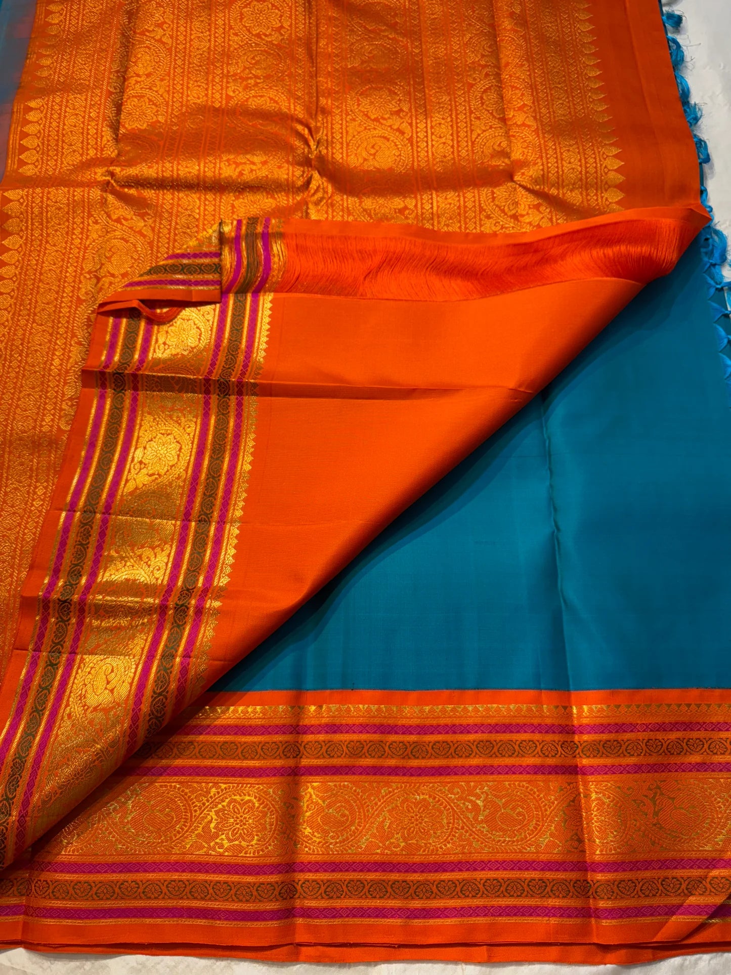 Aazhi Teal — Pure Kanchipuram Silk Saree
Teal body with silver-zari rosette buttas and korvai kavi–magenta borders in gold-zari brocade.
Silk Mark Certified • Free Shipping within USA • Ships in Two Weeks ✅