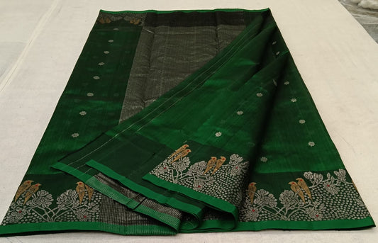 green chanderi silk saree laid flat showing full body and woven border
