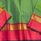 Close-up of green saree with wide pink border and gold zari woven peacock band, with dark piping on the edge.