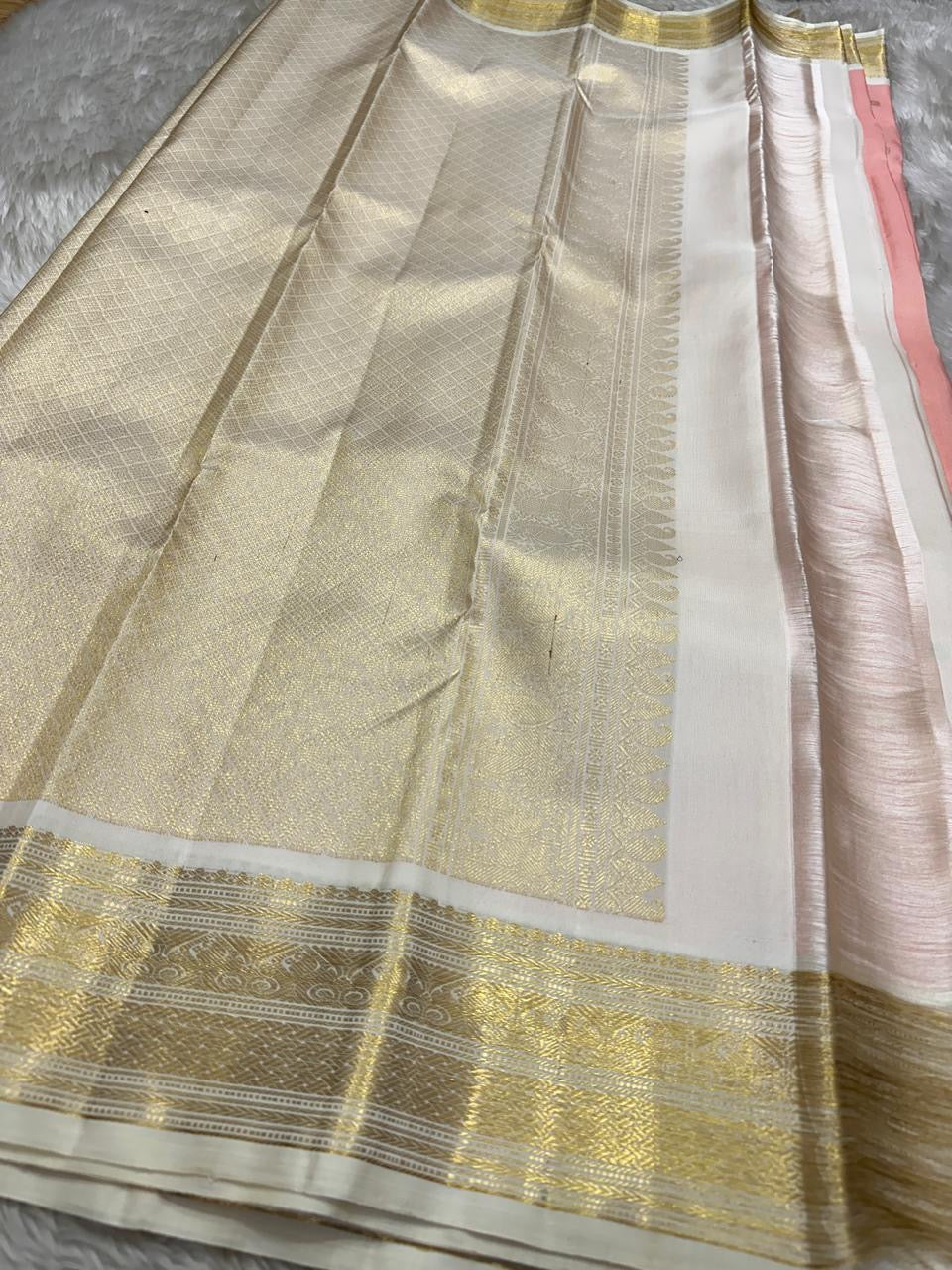 A serene blend of blush pink and pure white — soft, graceful pure silk Kanchipuram with kamalam zari butta and bavanji border and Pallu in cream