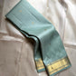 Mint Kattam – Pure Kanchipuram Silk Saree
Pastel Mint Green Body with Fine Zari Checks & Buttas
Broad Gold Zari Border with Textured Tissue Weave
Rich Gold Zari Pallu in Chevron & Striped Bands

Silk Mark Certified, delivery in 2 weeks