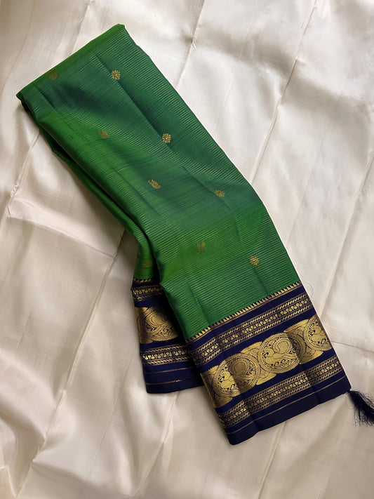 Pure silk adarpachai forest green  with royal blue zari lines all over , peacock motifs border and royal blue detailed Pallu