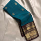 Neeli Megham – Pure Silk Kanchipuram
Teal-blue body with gold annapakshi buttas & aubergine korvai border in antique zari brocade
Silk Mark Certified • Fall & Pico Done • Blouse Stitching Available ($30) • Free Shipping within USA • Ships in Two Weeks
