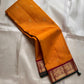 Saffron Royale – Pure Kanchipuram Silk Saree with Peacock Motif Border
Majestic saffron body with delicate zari buttas.
Rich maroon border woven with grand peacock motifs in  zari.
Traditional maroon pallu. Silk Mark Certified, delivery in 2 weeks