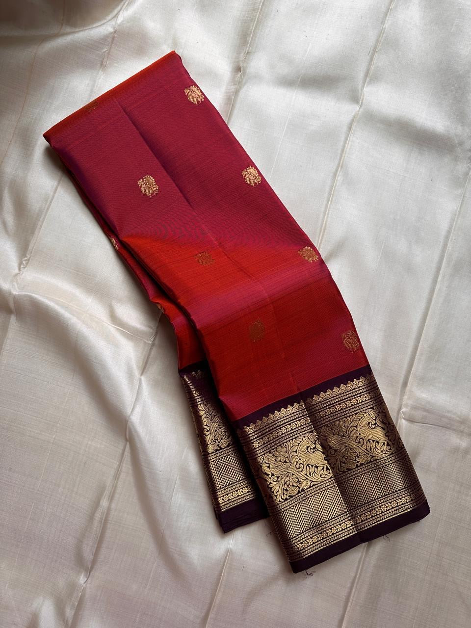 Shyama – Dusky Tangerine Kanchipuram Silk Saree with Purple Vanasringaram Border & Mayil Buttas