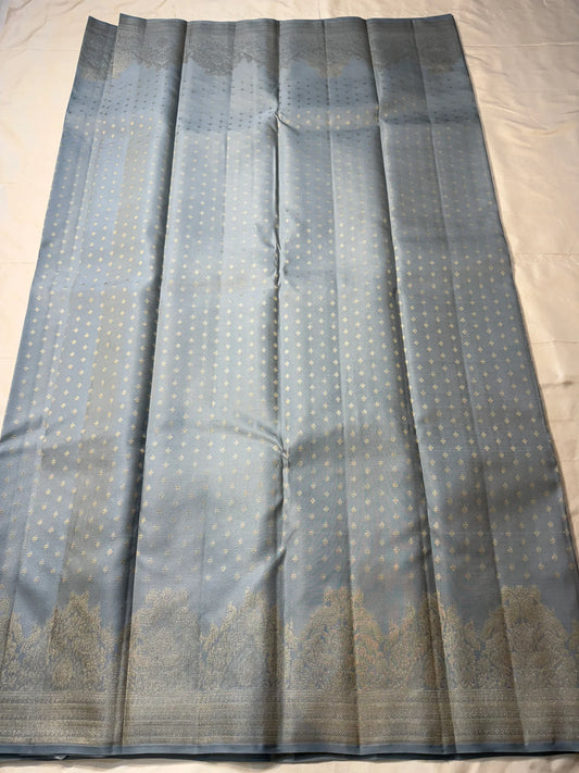 Chamomile — Kanchipuram Pure Silk

Pale gray-blue body with silver roopa buttas all over

Temple gopuram-inspired zari borders in luminous silver

Rich silver brocade pallu with intricate detailing

Silk Mark Certified • Free Shipping within USA