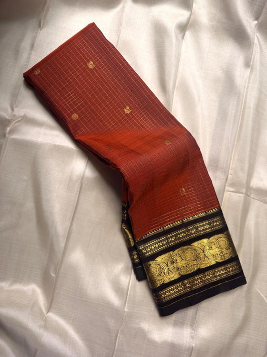Diya Rust Orange – Pure Silk Kanchipuram
Rust-orange kattam checks with coin buttas ✨
Coffee-brown korvai borders with grand Annam medallions 🪔
Rich coffee-brown brocade pallu with zari stripe weave 🌿
Silk Mark Certified • Ships in Two Weeks • Free Ship