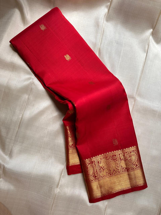 Dia ✨ – Chilli Red Pure Kanchipuram Silk Saree
Allover Gold Zari Floral Buttas on Body
Broad Elephant–Peacock (Gaja–Mayil) Zari Panel Border
Rich Red & Gold Brocade Pallu with Intricate Weaves
Silk Mark Certified | Fall & Pico Done | Blouse Stitching $30