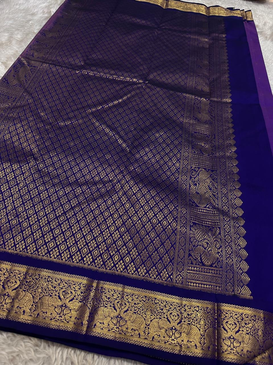 Vadamalli Yaanai – Pure Kanchipuram Silk Saree
Royal purple body with delicate gold zari floral medallion buttas
Ornate yaanai procession borders with vine detailing in zari
Ships in two weeks silk mark certified