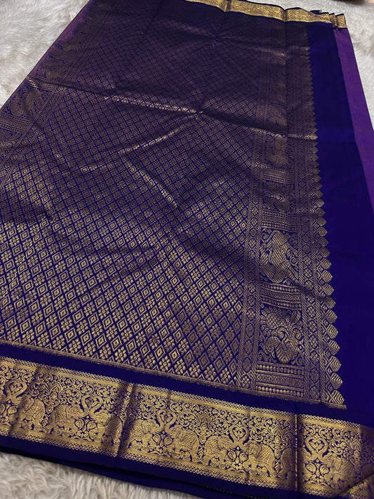 Vadamalli Yaanai – Pure Kanchipuram Silk Saree
Royal purple body with delicate gold zari floral medallion buttas
Ornate yaanai procession borders with vine detailing in zari
Ships in two weeks silk mark certified