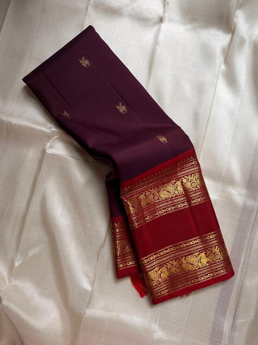 Purnima ✨ – Kumkum-Red & Aubergine Kanchipuram Pure Silk Saree
With Zari Winged Horse Buttas on the Aubergine Body
Grand Gold Annam & Floral Korvai Border with Temple Rekku
Varisaipettu Striped Gold Brocade Pallu with Hand-Knotted Tassels
Silk Mark