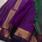 Varnam is a pure Kanchipuram silk saree in rich emerald green with subtle dual-tone shading. Woven gold zari buttas dot the body, while a petite purple border woven with intricate zari adds refined contrast. Arai maadam Pallu, jewel toned classic !