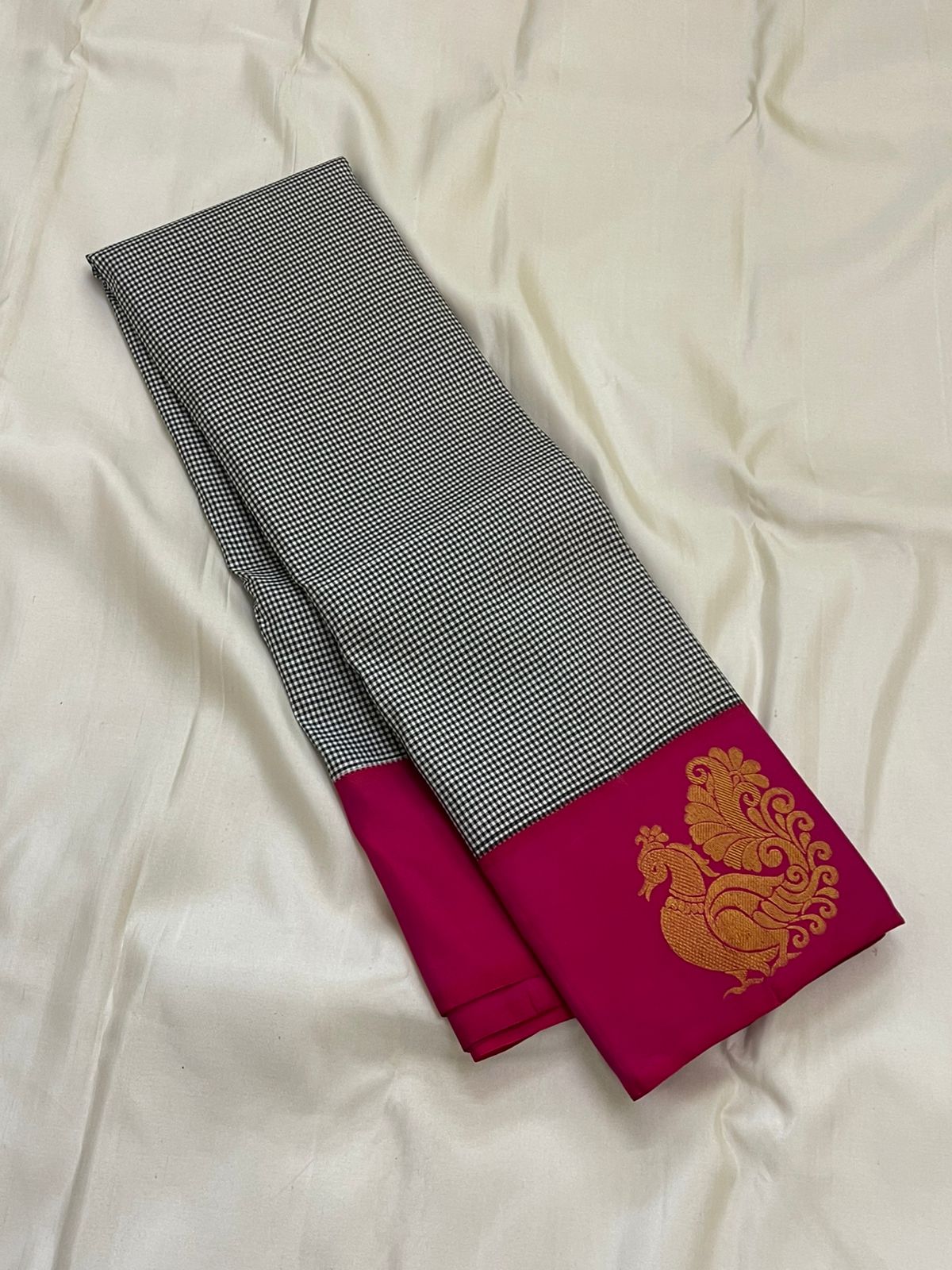Aaradhana Kattam — Pure Kanchipuram Silk Saree (Black & White × Rani Pink)
Classic black-and-white micro checks with rich rani-pink korvai borders and zari peacock motifs
Silk Mark Certified • Fall & Pico Done • Blouse Stitching Available ($30) • Free Shi