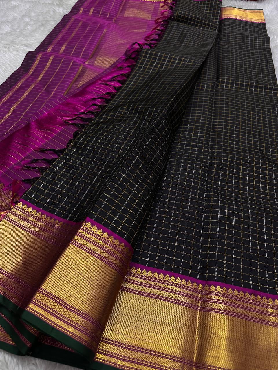 Charcoal Zari Kattam – Pure Kanchipuram Silk Saree
Rich Charcoal Black Body with Gold Zari Checks
Broad Golden Border with Magenta Highlights & Green Selvedge
Royal Magenta Pallu with Lustrous Zari Stripes

Silk Mark Certified, delivery in 2 weeks