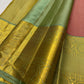 Vahini – Pleasant Peach Pink Pure Kanchipuram Silk Saree with Zari Kattam Checks, Silver & Gold Peacock Buttas, Sage Green Border Adorned with Kamalam Vines and Baavanji Motifs, and an Ornate Zari Pallu with Majestic Peacocks