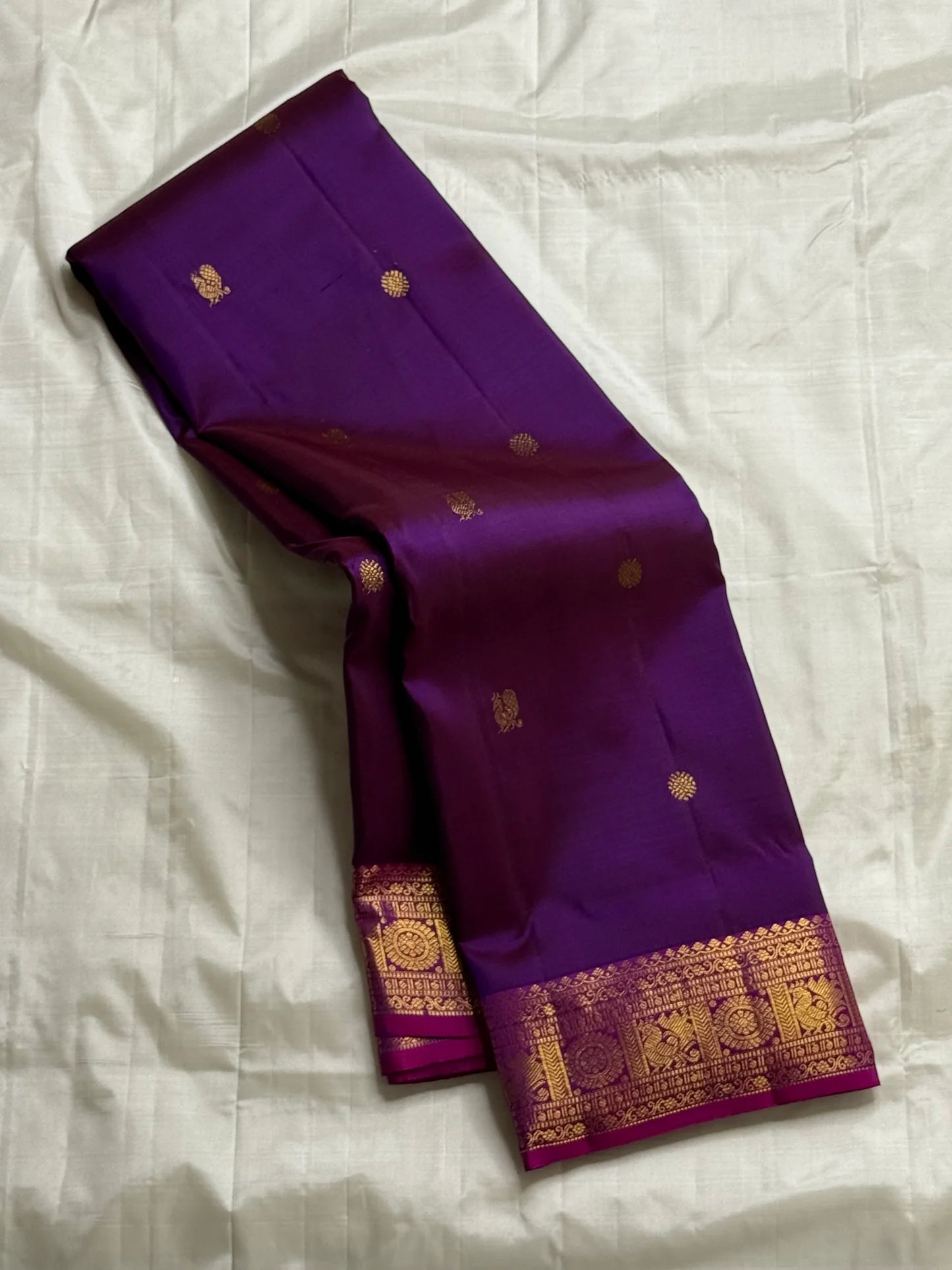 Vedhavalli — Pure Silk Kanchipuram Saree
Royal purple with gold mango buttas & korvai fuchsia border
Magenta–gold brocade pallu, tasselled finish
Silk Mark Certified ✅ • Free USA Shipping ✅ • Ships in Two Weeks ✅
