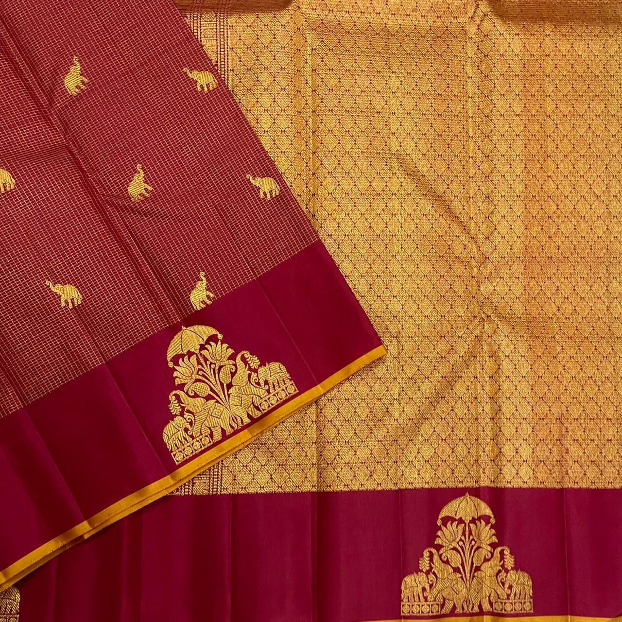 Detail of wine border with gold thiruvizha motif next to the gold zari pallu on maroon zari kattam silk saree.