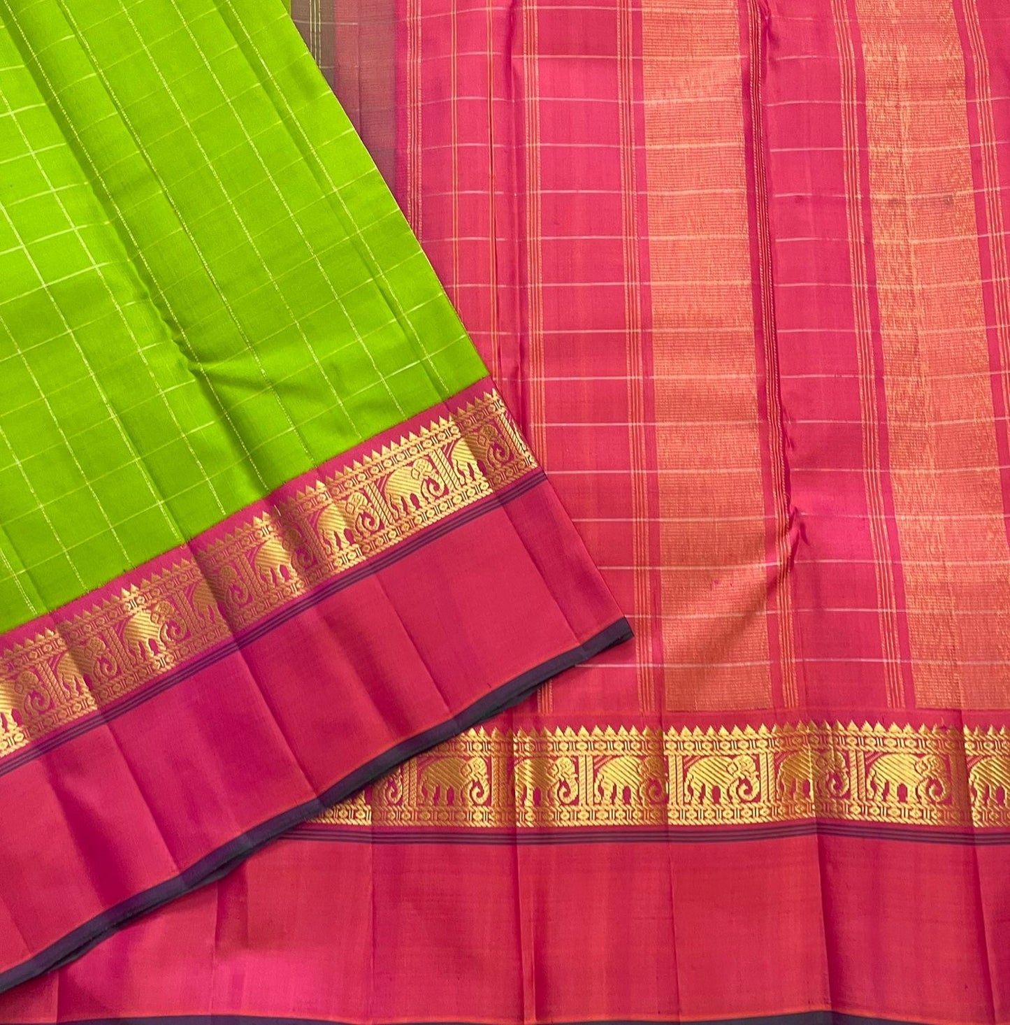 Valli Pachai – Kanchipuram Pure Silk Saree

Parrot-green body in kattam (grid) checks with subtle zari lines

Korvai contrast rani-pink borders featuring gaja (elephant) procession & temple reku motifs

Rich rani-pink zari pallu with vertical bands