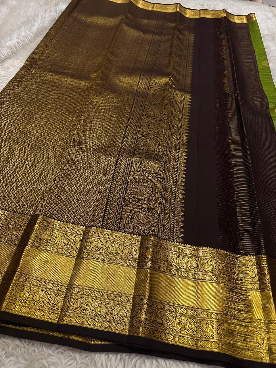 Forest Gold – Pure Kanchipuram Silk Saree
Leaf-green body with fine pin stripes.
Zari leaf buttas for subtle sparkle.
Coffee-maroon korvai border in antique gold.

Silk Mark Certified, delivery in 2 weeks