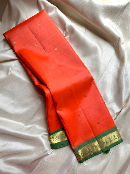 Pure silk kanchipuram orange peach  color body with zari buttas , green mayil slim border
