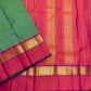 Green saree with pink border and gold zari woven band laid over a pink pallu with vertical zari stripes and gold panels.
