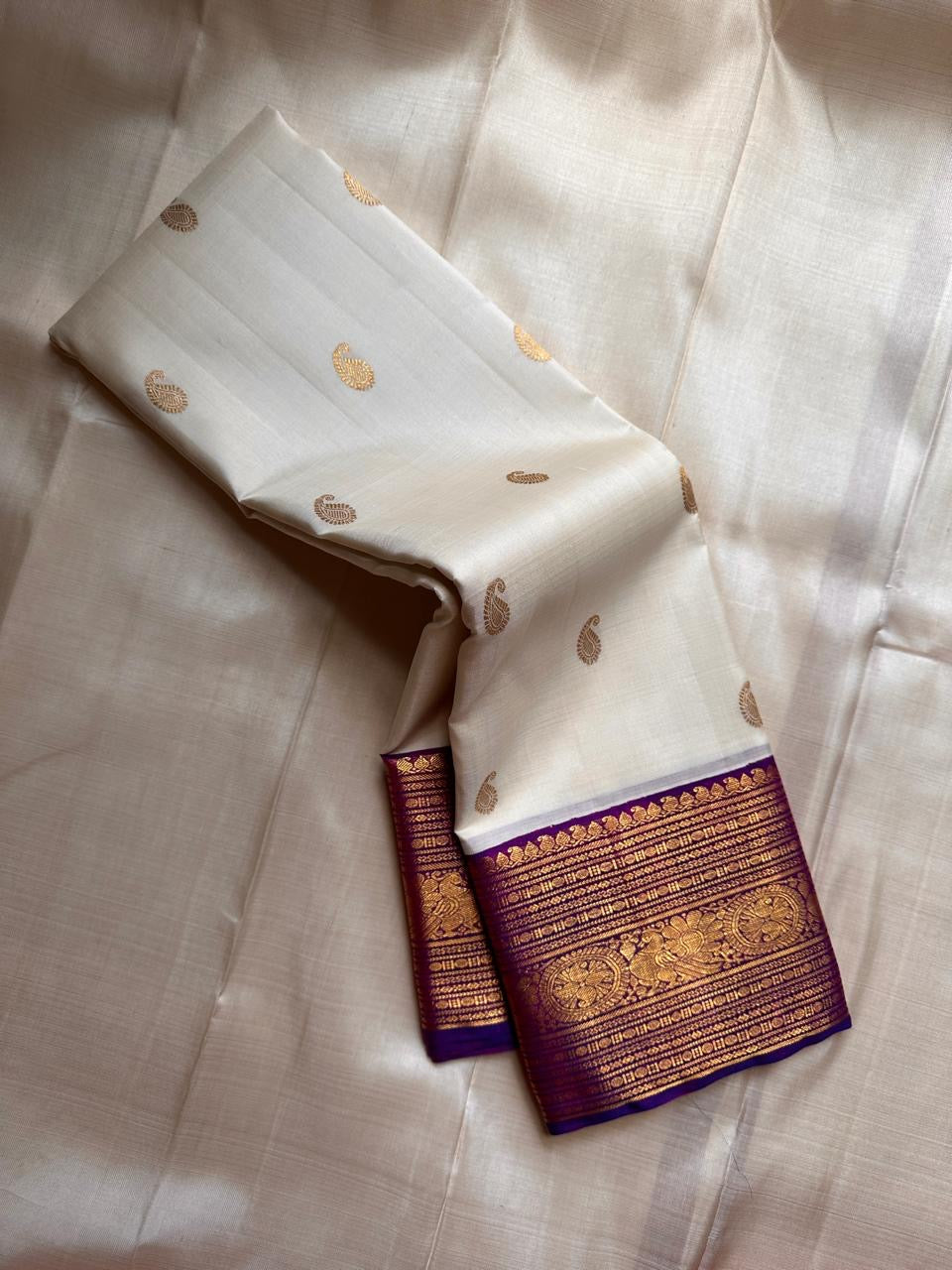 Hamsa Paisley — Pure Handloom Kanchipuram Silk Saree 
Ivory Body with Gold Paisley Buttas & Royal Purple Brocade Border ✨
Silk Mark Certified • free shipping within Usa ships in two weeks