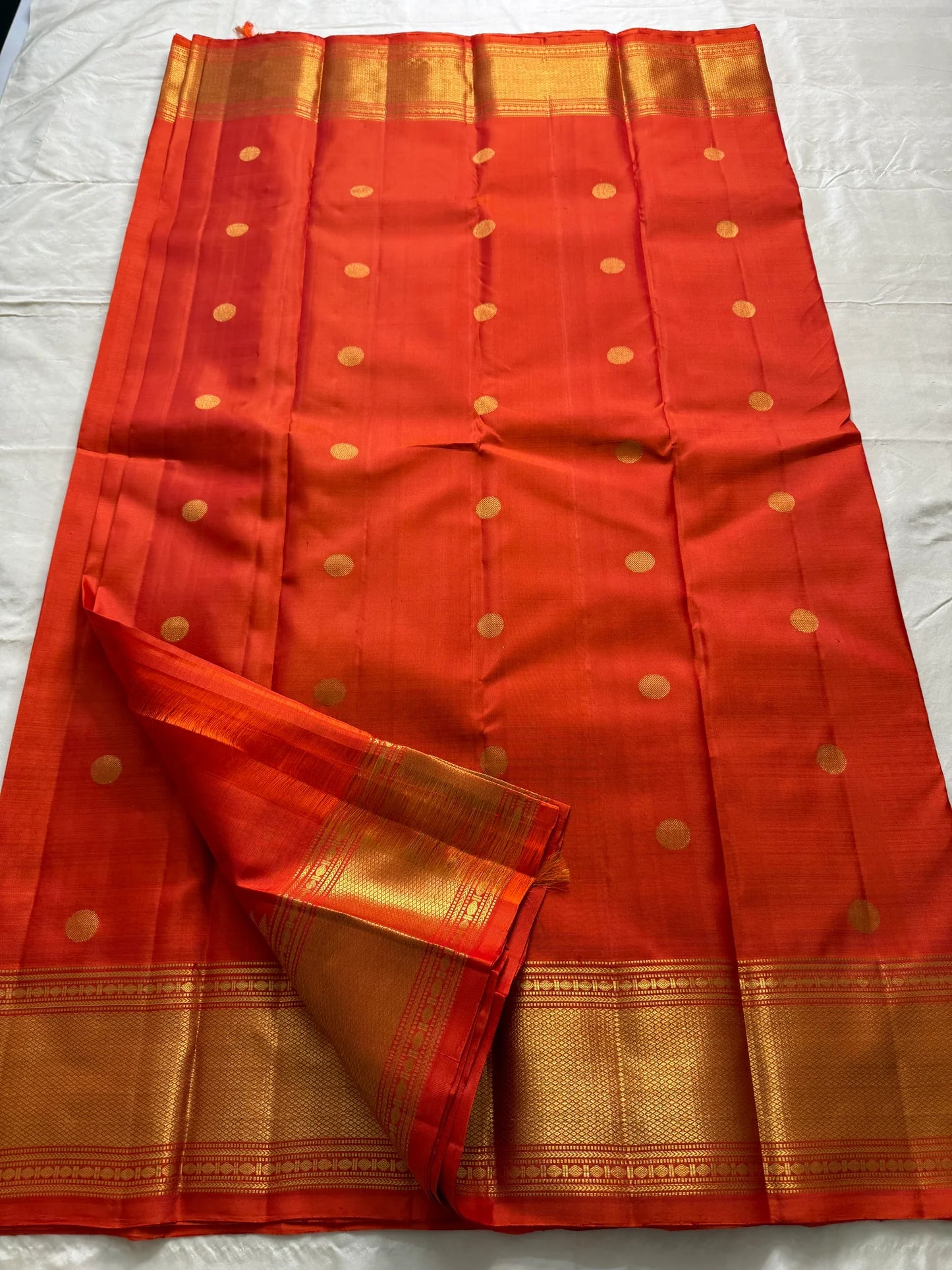 Maya
Vibrant Orange Kanchipuram Silk Saree with Lustrous Gold Coin Buttas
Handwoven Traditional Rudhraksham Seer and Intricate Arai Maadam Zari Border
Richly Crafted Pallu Featuring Elegant Gold Zari Panels for a Regal Finish