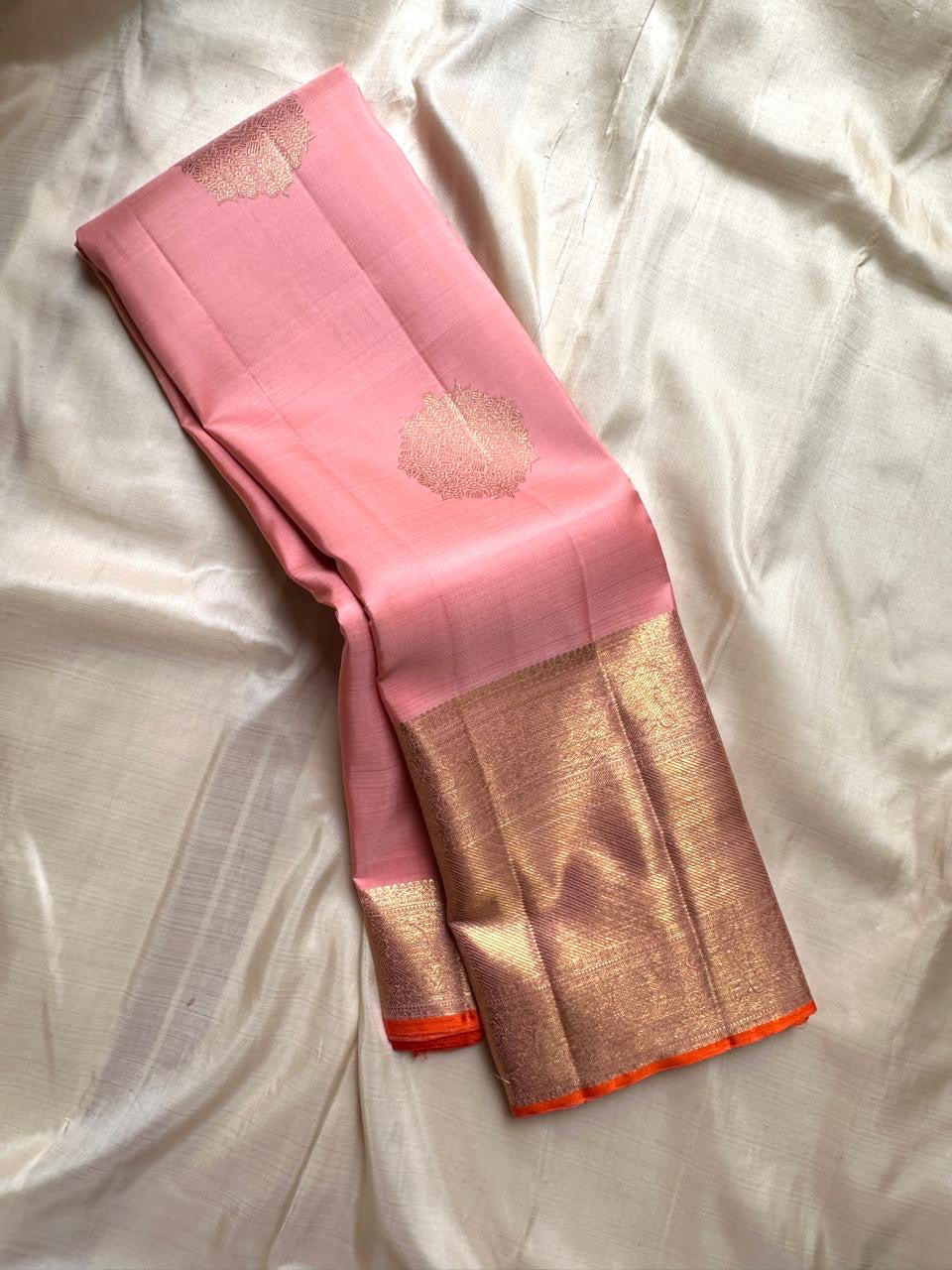 Lalima 🌸 – Bud Pink Pure Silk Saree
Featuring Large Ornate Floral Motifs Woven in 3g Pure Zari ✨
Adai Madam Floral & Vine Borders with Majestic Baavanji & peacock motif Layers 🌿 🦚
Finished with a Crimson-Orange Selvedge for Stunning Contrast 🔥